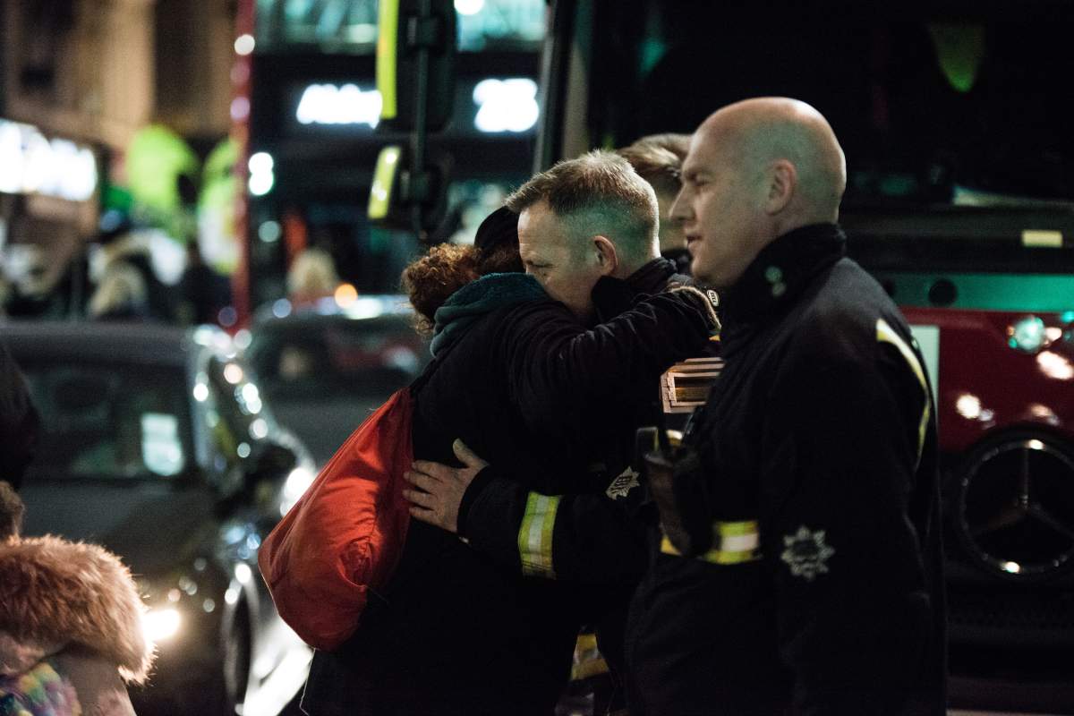 Firefighters seen giving a hug to local people during the monthly silent march for the Grenfell Tower fire victims. (Photo by Brais G Rouco/SOPA Images/LightRocket via Getty Images)
