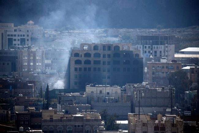 Smoke billows behind a building in the Yemeni capital Sanaa on Dec. 3, 2017, during clashes between Huthi rebels and supporters of Yemeni ex-president Ali Abdullah Saleh.