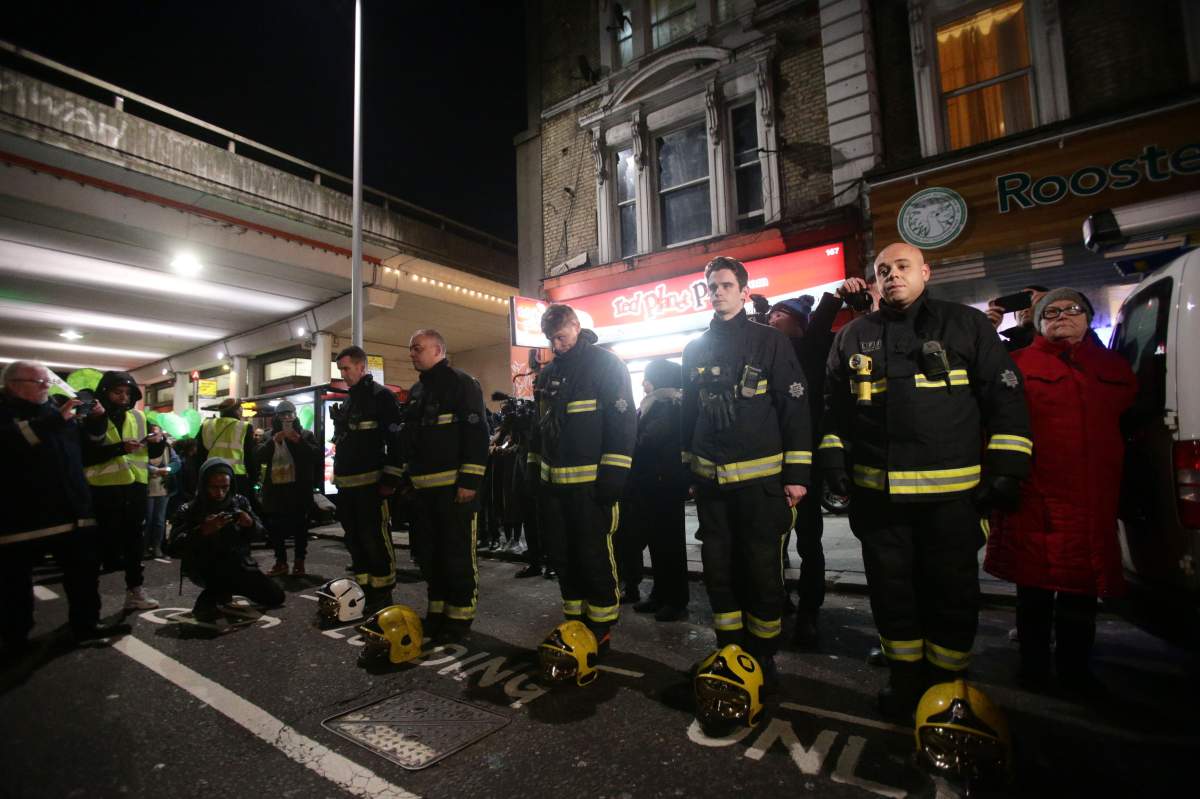 Firefighters pay their respects as people take part in a silent walk to mark the six month anniversary of the Grenfell Tower fire, in west London. (Photo by Yui Mok/PA Images via Getty Images)