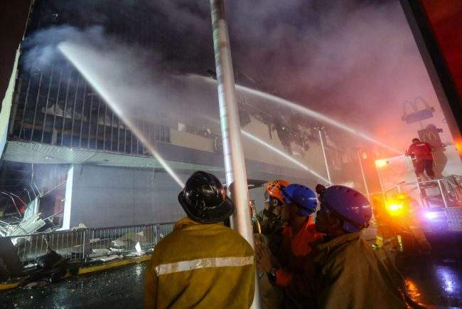Firefighters extinguish a fire at a shopping mall in Davao City on the southern Philippine island of Mindanao, Dec. 23, 2017.