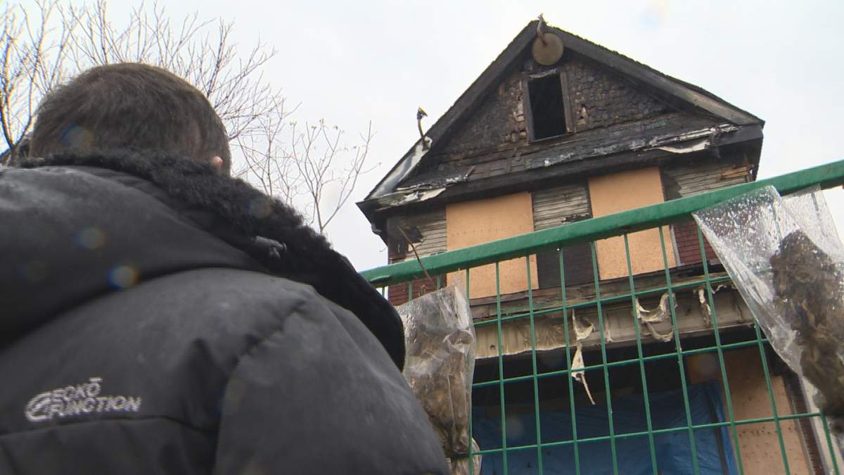 Daniel LeBlanc, 26, stands outside the burned out shell of 70 Niagara St. in Hamilton, Ont.