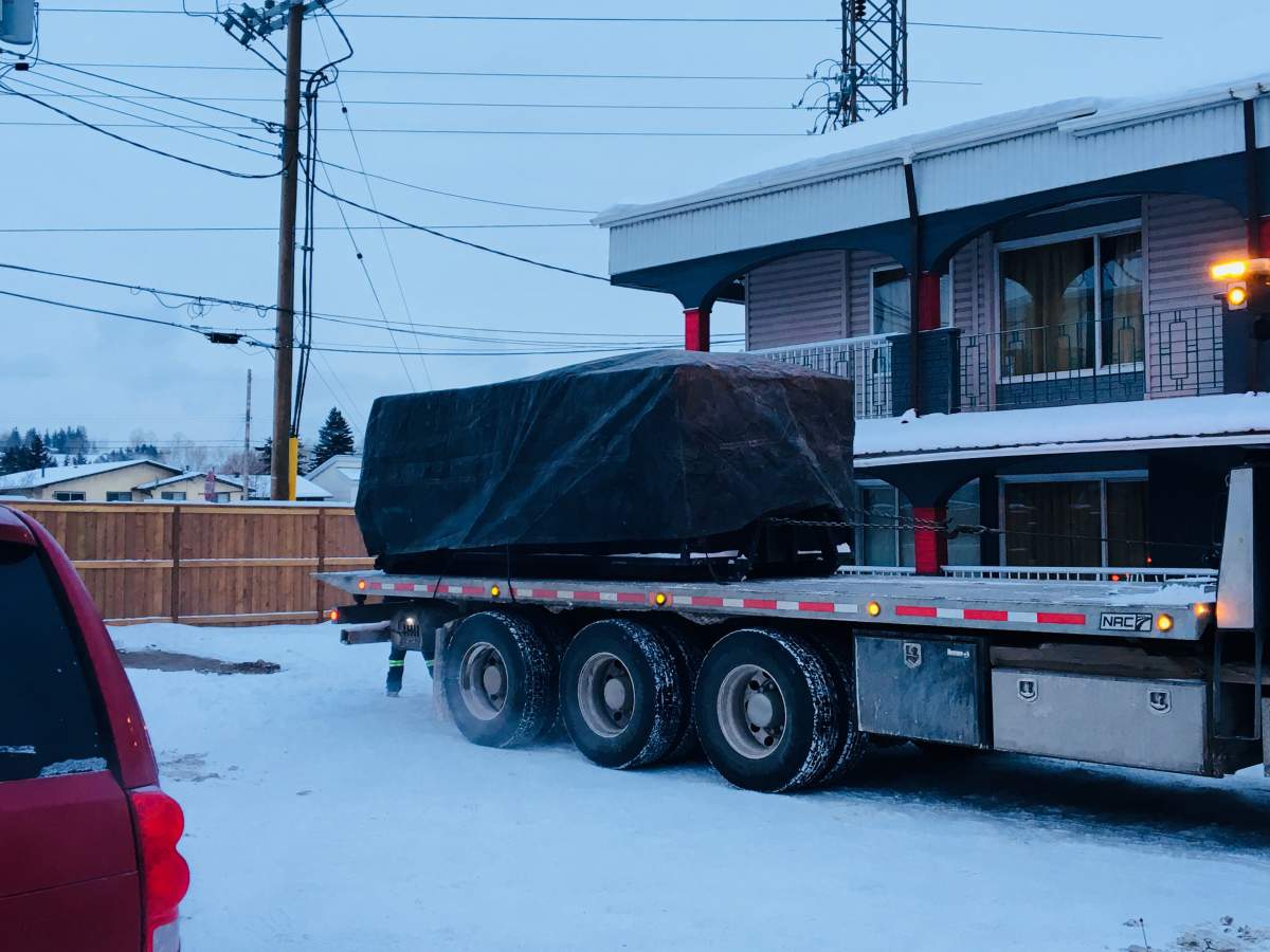 A dumpster is seen on a flatbed to be towed away from outside the Olympia Motel and Lodge on Dec. 29.