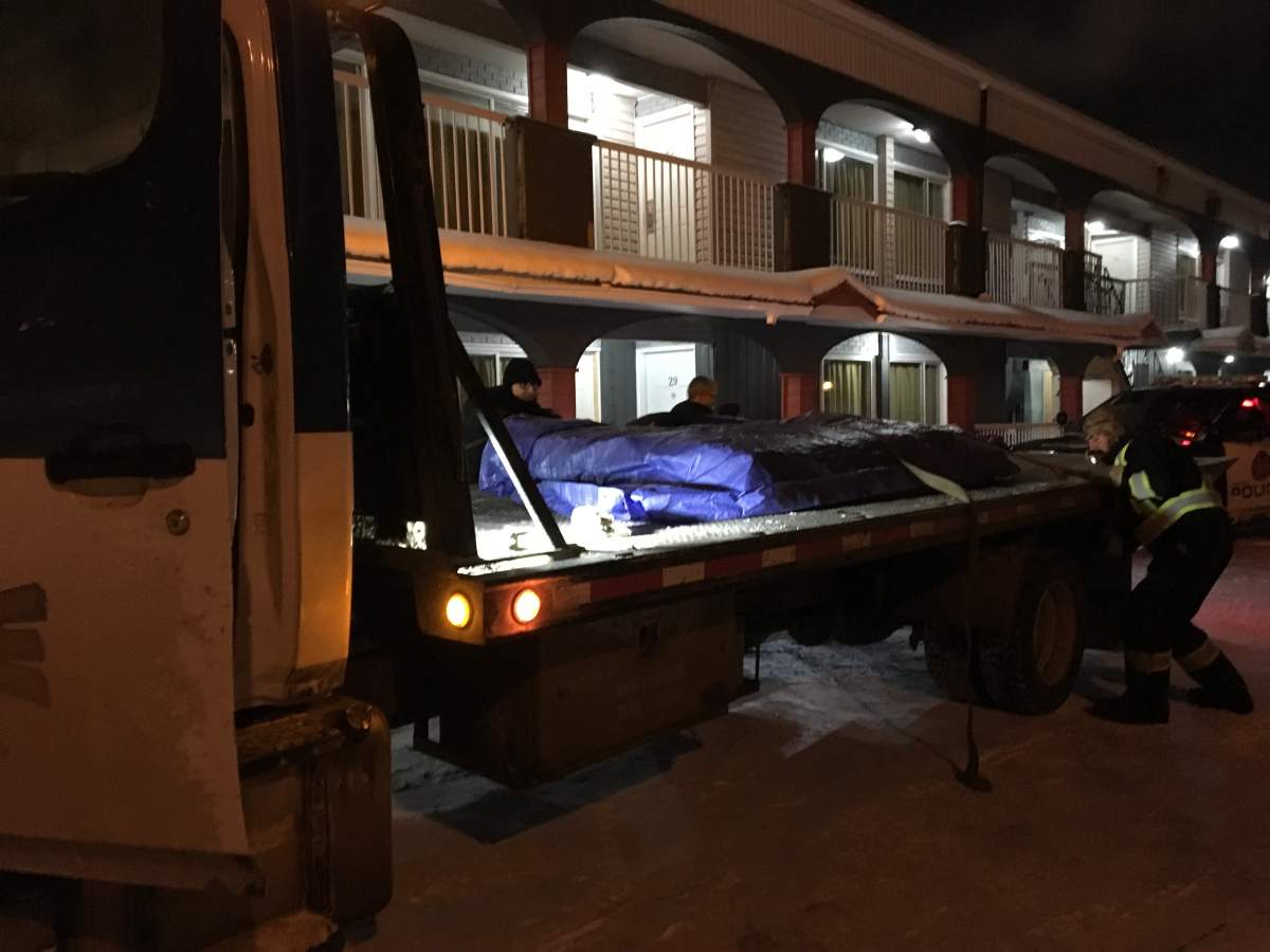 A mattress wrapped in a tarp is seen being taken away from the Olympia Motel and Lodge on Dec. 29.