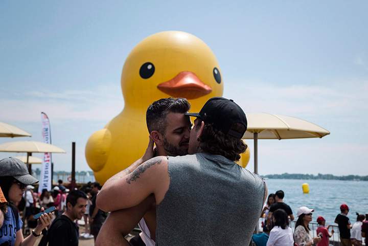 Mateo McIntyre and Steven Ernewein share an intimate moment while celebrating Canada Day near the giant inflatable duck that sits on Toronto’s Harbourfront on July 1, 2017.
