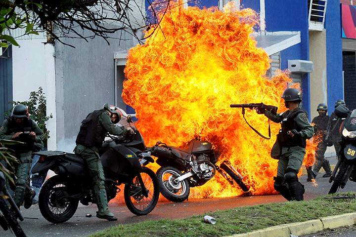 Riot security forces clash with demonstrators as a motorcycle is set on fire during a protest against Venezuelan President Nicolas Maduro’s government in San Cristobal, May 29, 2017.
