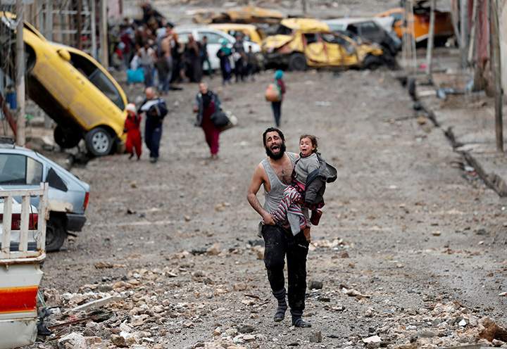 A man cries as he carries his daughter while walking from an Islamic State-controlled part of Mosul towards Iraqi special forces soldiers during a battle in Mosul, Iraq, March 4, 2017.
