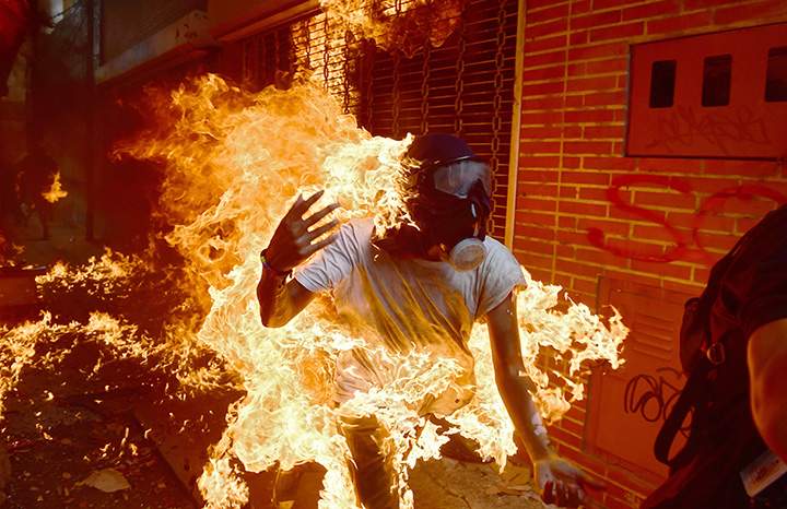 A demonstrator catches fire during clashes with riot police within a protest against Venezuelan President Nicolas Maduro, in Caracas on May 3, 2017.