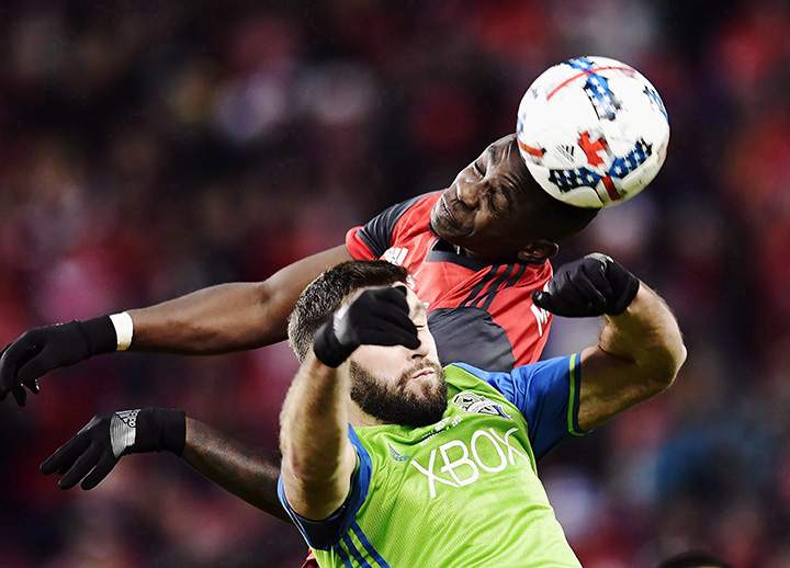 Toronto FC defender Chris Mavinga heads the ball above Seattle Sounders defender Will Bruin during the first half of the MLS Cup Final in Toronto on Saturday, December 9, 2017.