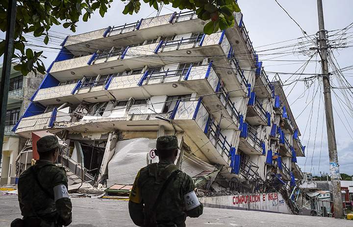 Soldiers stand guard a few metres away from a hotel that collapsed following a powerful earthquake that struck Mexico, September 8, 2017.
