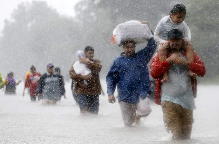 Residents wade through floodwaters from Tropical Storm Harvey in Houston, Texas, on August 28, 2017.