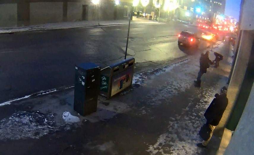 This surveillance camera image shows the suspect crouching over the victim (top right).
