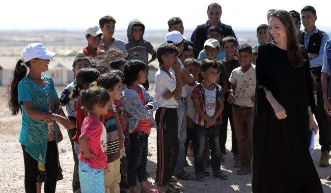 Actress and UN refugee agency envoy special envoy Angelina Jolie smiles at children during a visit to a Syrian refugee camp in Azraq in northern Jordan, Sept. 9, 2016. 

