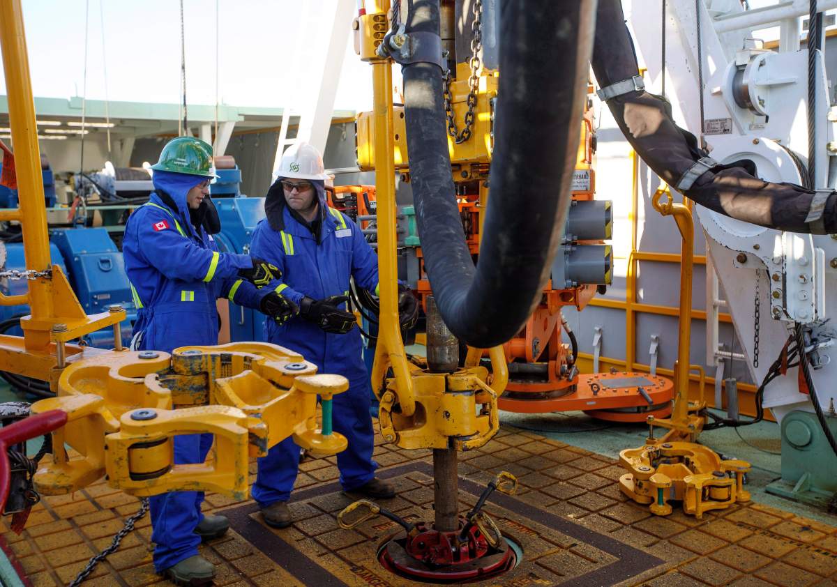 Trainee Kyle Robinson, left, talks with instructor Clint Dyck train to lay down drill pipe on a rig floor at Precision Drilling in Nisku, Alta., on Friday, January 20, 2016.