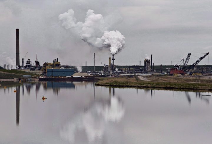 The Syncrude oil sands extraction facility is reflected in a tailings pond near the city of Fort McMurray, Alta., on June 1, 2014.