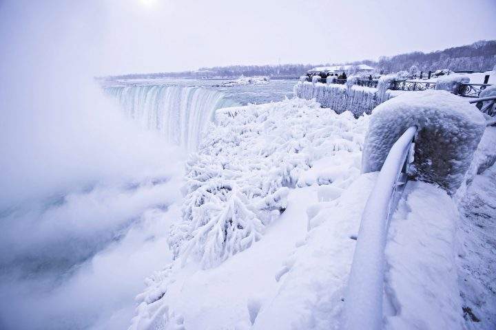 Visitors take photographs at the brink of the Horseshoe Falls in Niagara Falls, Ont., as cold weather continues through much of the province on Friday, Dec. 29, 2017.