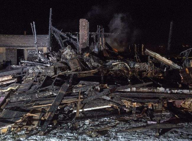 The remains of a house destroyed in an early morning fire are seen in Pubnico Head, N.S. on Sunday, Jan. 7, 2018.