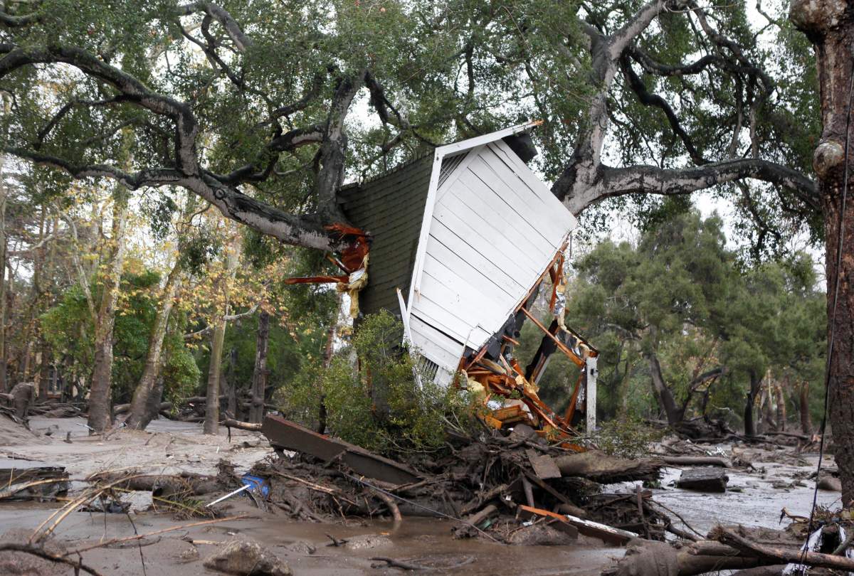 A structure is smashed against a tree along Hot Springs Road in Montecito, Calif. after getting hit by a flash flood and debris flow on Tuesday.