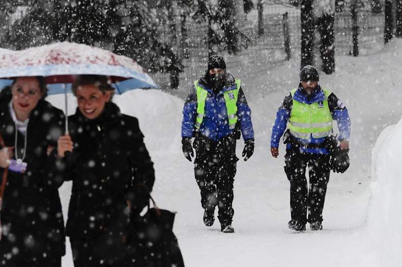 Two police officers patrol through the snow near the congress centre where the World Economic Forum, WEF, will take place in Davos, Monday, Jan. 22, 2018.