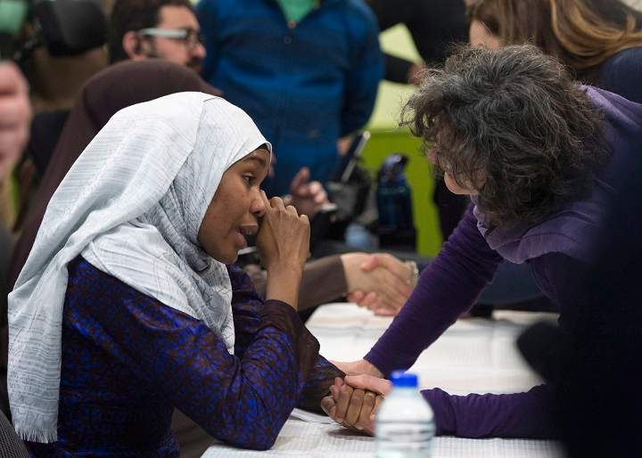 Idiatou Barry, left, wipes her eyes as she speaks with a woman during a gathering at the Centre Islamique de Quebec, marking the first anniversary of the mosque shooting, Saturday, January 27, 2018 in Quebec City. Barry lost her husband, Mamadou Tanou Barry, in the shooting.