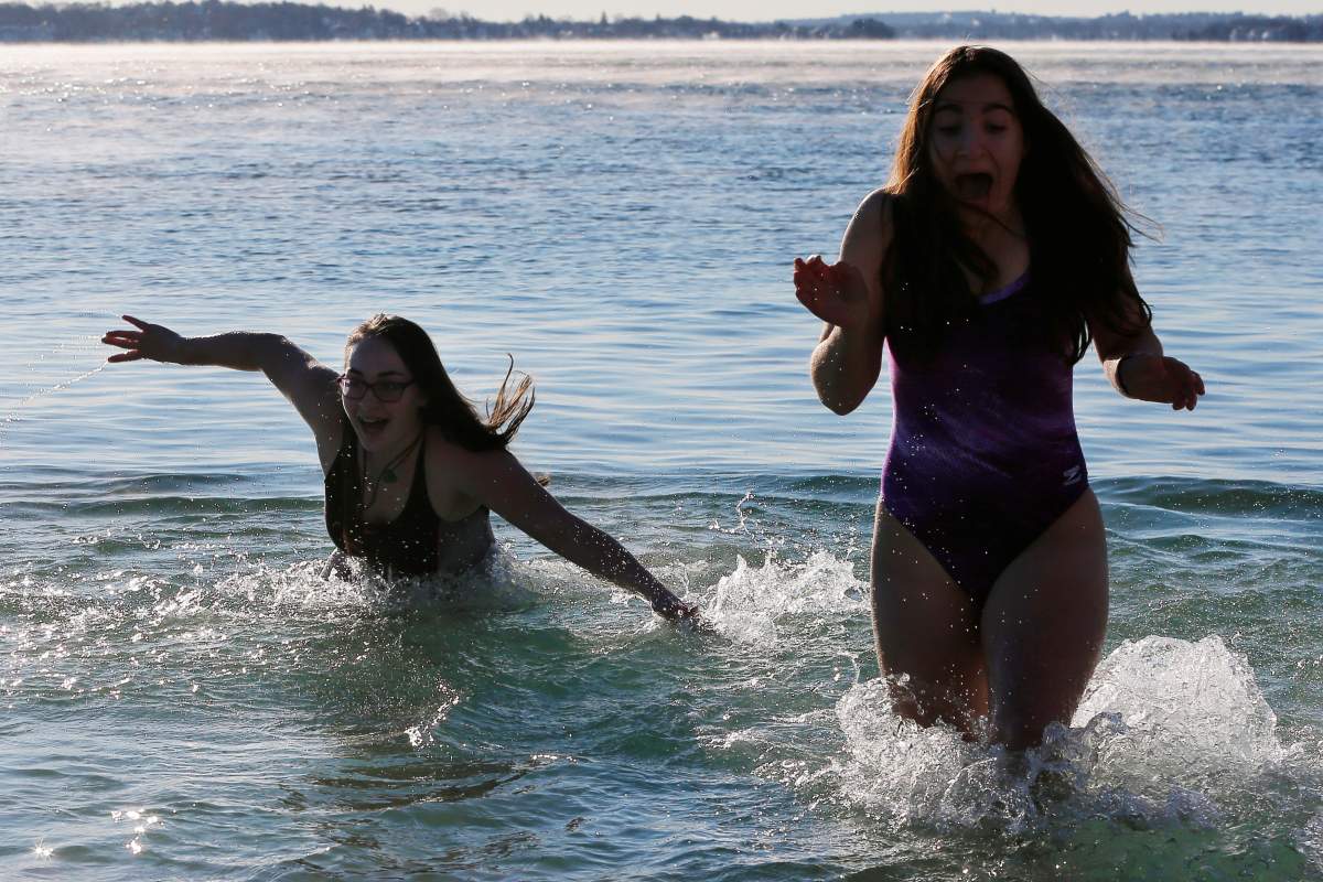 Two women react while taking part in the annual New Year’s Day L Street Brownies Polar Bear Plunge, with the air temperatures at zero degrees Fahrenheit, in Boston, Massachusetts, U.S., January 1, 2018. REUTERS/Brian Snyder