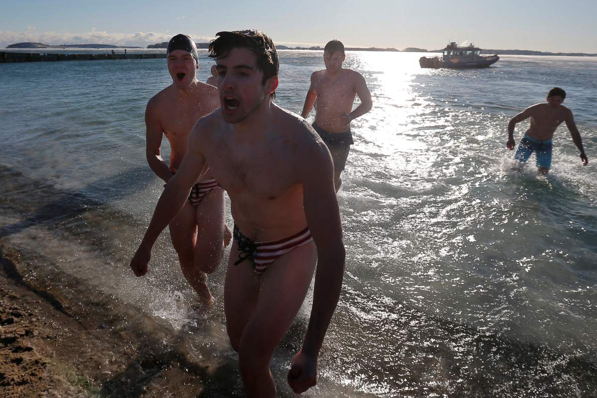 Men reacts after going into the ocean during the annual New Year’s Day L Street Brownies Polar Bear Plunge, with the air temperatures at zero degrees Fahrenheit, in Boston, Massachusetts, U.S., January 1, 2018. REUTERS/Brian Snyder