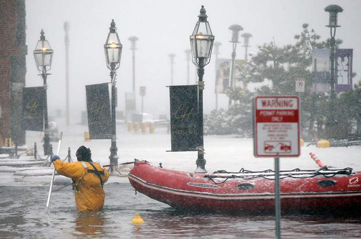 A firefighter wades through floodwaters from Boston Harbor on Jan. 4, 2018.