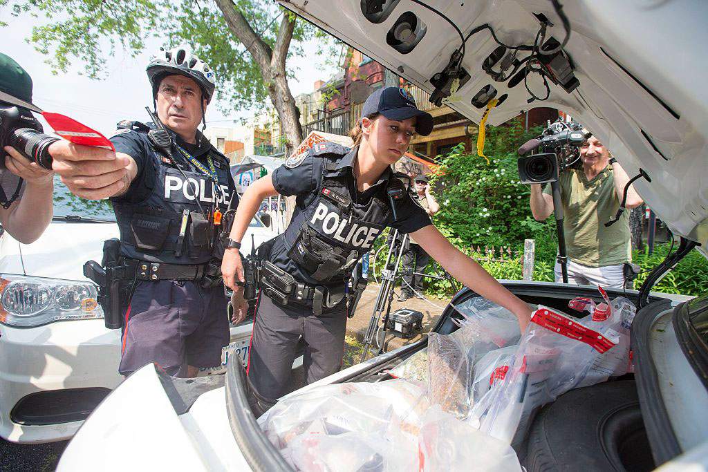Police remove marijuana products from Cannawide dispensary in Toronto on May 26, 2016.   