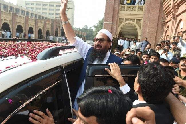 Pakistan head of the Jamaat-ud-Dawa (JuD) organisation Hafiz Saeed (C) waves to supporters as he leaves a court in Lahore on October 19, 2017.


