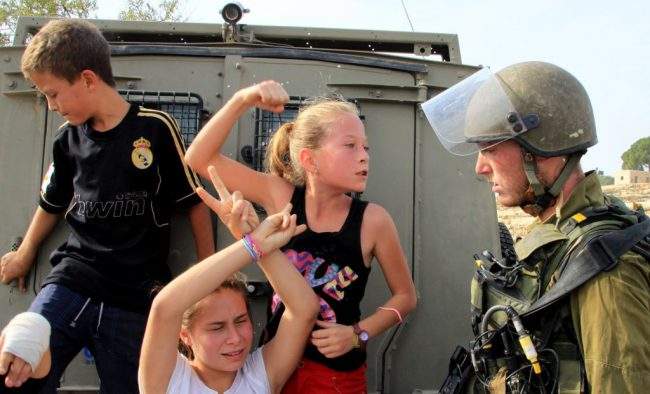 This Nov. 2, 2012 file photo shows Ahed al-Tamimi challenging Israeli soldiers during a protest in Ramallah, West Bank.