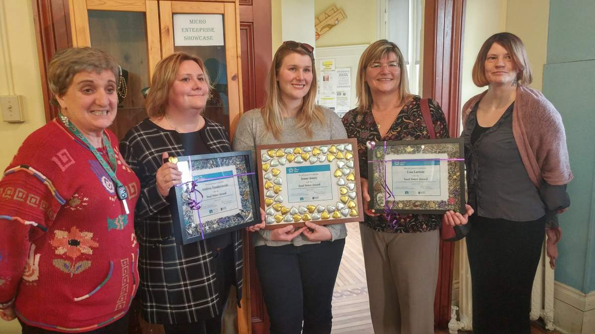 Elizabeth Rankin's daughters Andrea Vanderweide (second from the left) and Lisa Larson (second from the right) pose for a picture with women who have benefited from the women's empowerment programs at My Sister's Place.