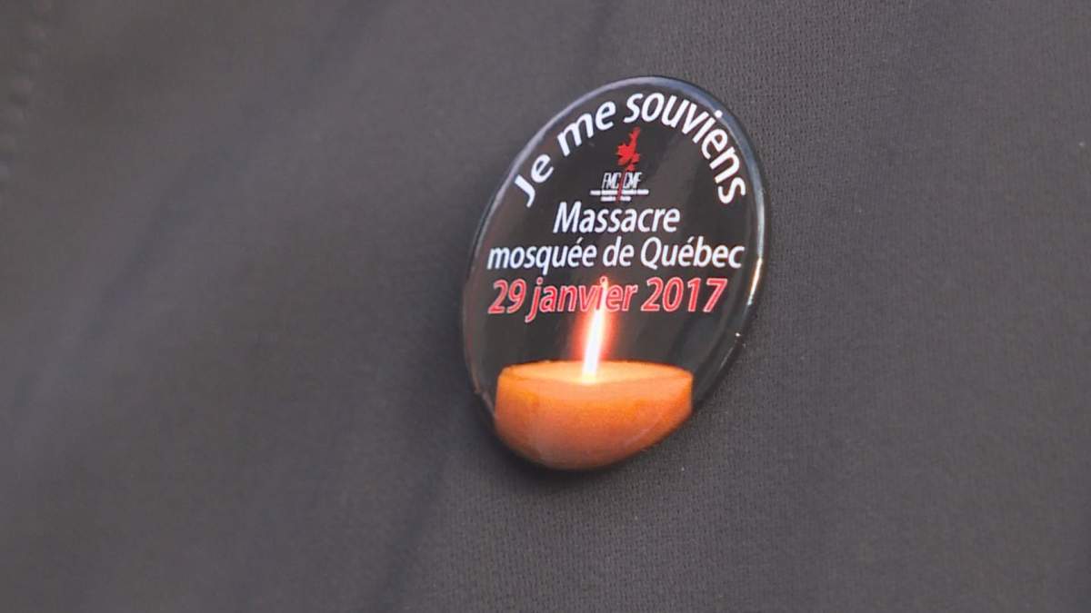A woman wears a pin commemorating the first anniversary of the Quebec City mosque shooting, during an event in Montreal, Sunday, Jan. 28, 2018.  