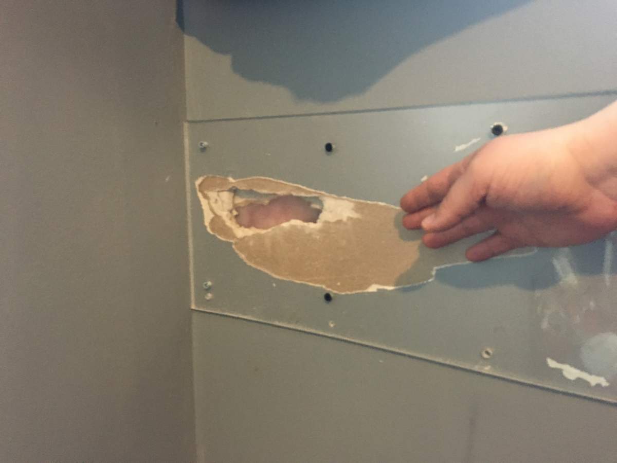 Plexiglass covers a hole in the wall at Crystal and A.J. Wyre’s home. Their son, Dakota, broke through the gyprock to the insulation.