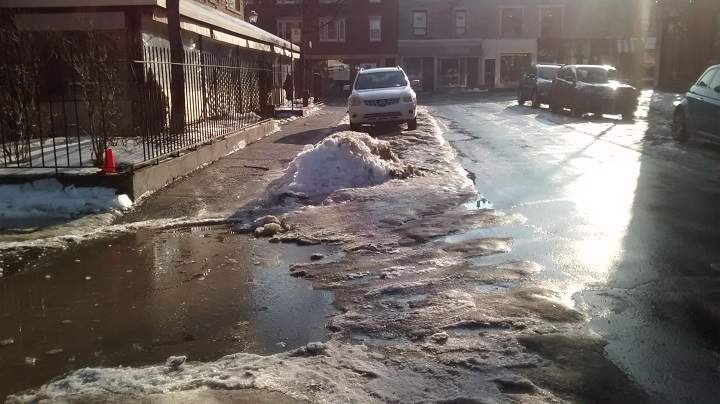 Montreal sidewalks disappear under puddles of icy water. The city will be launching a snow removal operation Sunday night to clear the remnants of a storm earlier in the week. Sunday, Jan. 28, 2018.