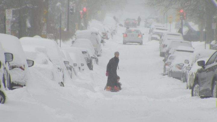 Child being pulled in a sled on Montreal street during winter storm. Saturday, Jan. 13, 2018. Jonah Aspler/Global News