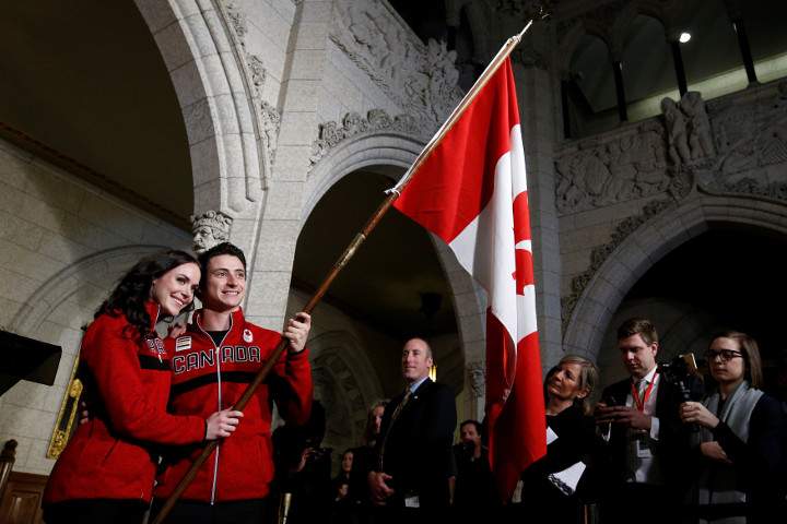 Ice dancers Tessa Virtue and Scott Moir pose with a flag after being named Canada’s flag-bearers for the opening ceremony of the 2018 Pyeongchang Winter Olympic Games during an event on Parliament Hill in Ottawa, January 16, 2018.