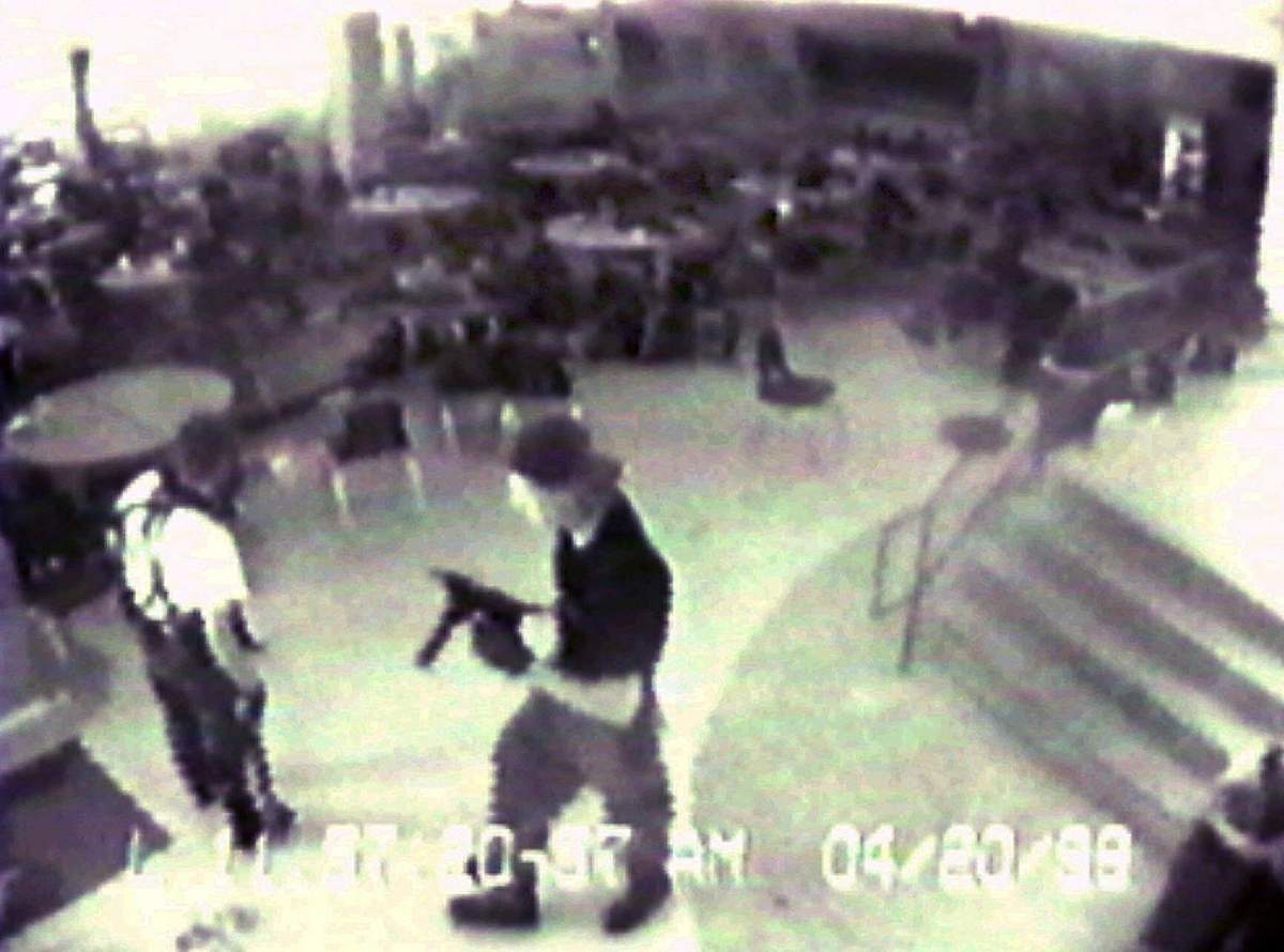 Eric Harris, left, and Dlyan Klebold, carrying a TEC-9 semi-automatic pistol, are pictured in the cafeteria at Columbine High School, in Littleton, Colo., during their April 20, 1999 shooting rampage where they killed a teacher and 12 students. Both gunmen killed themselves later in the school library.