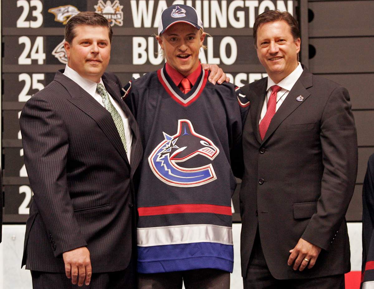 Michael Grabner (centre) poses for a photo with Vancouver Canucks general manager Dave Nonis (left) and Steve Tambellini after the Canucks selected Grabner with the 14th overall pick in the 2006 NHL Entry Draft in Vancouver, B.C., Saturday, June 24, 2006.