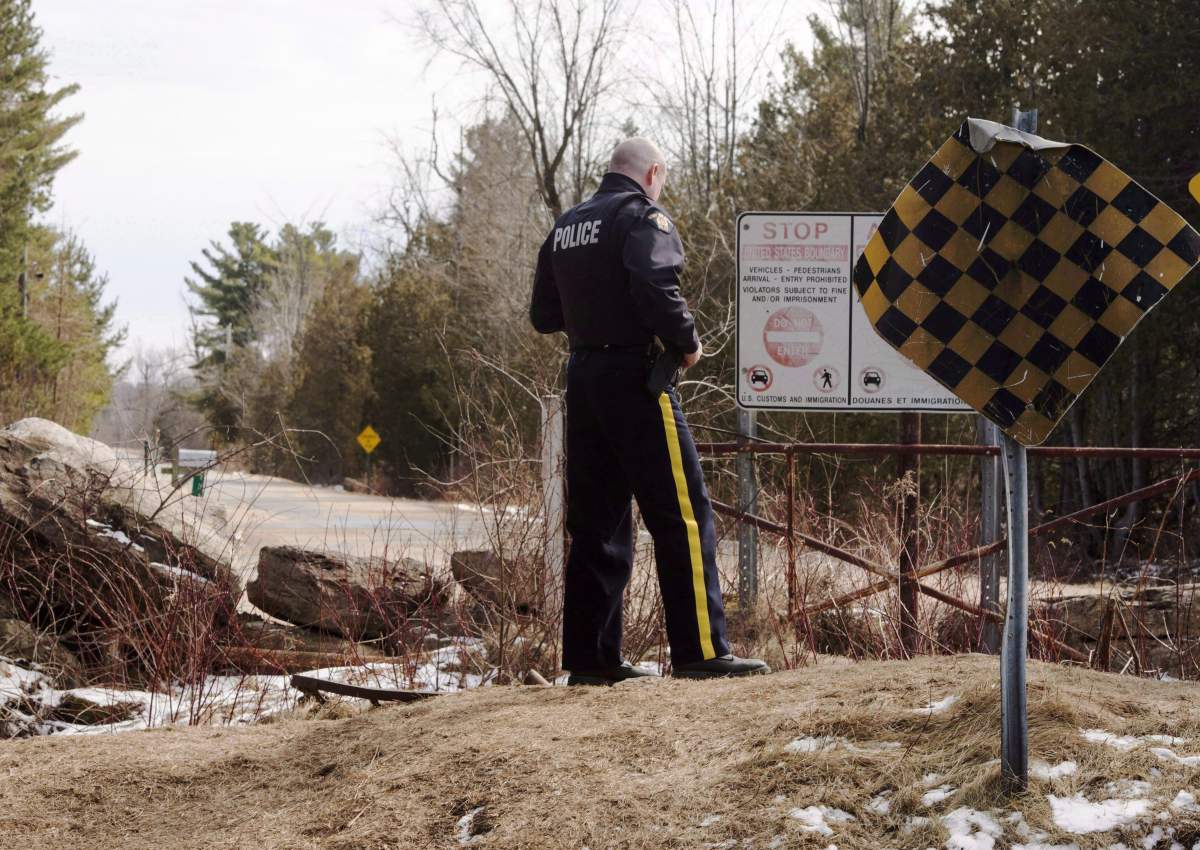 An RCMP officer keeps watch for illegal aliens at the border from New York into Canada, Monday, March 6, 2017 in Hemmingford, Quebec.