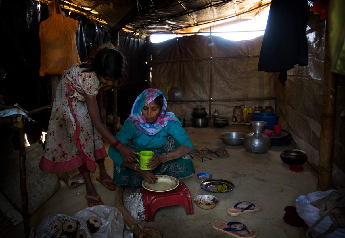 In this Jan. 28, 2018 photo, Rohingya Muslim refugees Nooranksih, 9, left, and her mother Rohima Khatu, 45, originally from the Myanmar village of Gu Dar Pyin, eat inside their makeshift shelter at Balukhali refugee camp.
