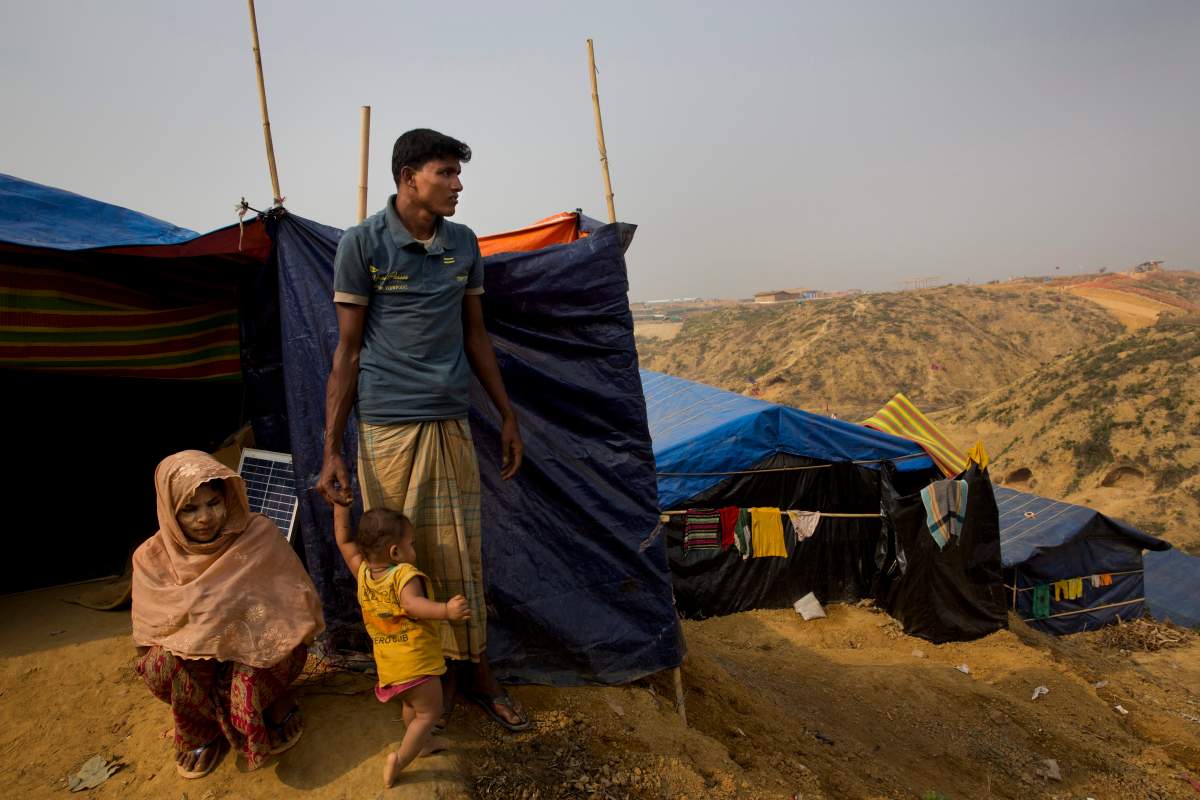 In this Jan. 14, 2018 photo, Rohingya Muslim refugee Mohammad Younus, 25, from the Myanmar village of Gu Dar Pyin, stands on a hill of Kutupalong refugee camp, Bangladesh. When Mohammad Younus, 25, heard explosions from hand grenades and rocket launchers, he ran to the road. He was shot twice while trying to call his family. One of the bullets, still in his hip, can be seen when he pinches the skin.