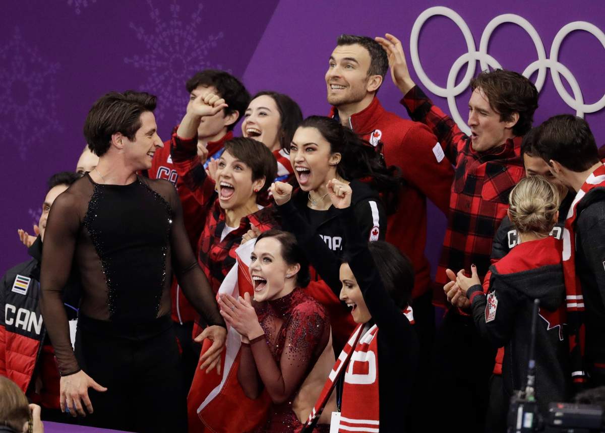 Scott Moir and Tessa Virtue of Canada celebrate with teammates after their score was posted in the ice dance free dance figure skating team event in the Gangneung Ice Arena at the 2018 Winter Olympics in Gangneung, South Korea, Monday, Feb. 12, 2018. Canada won the gold medal for the team event.