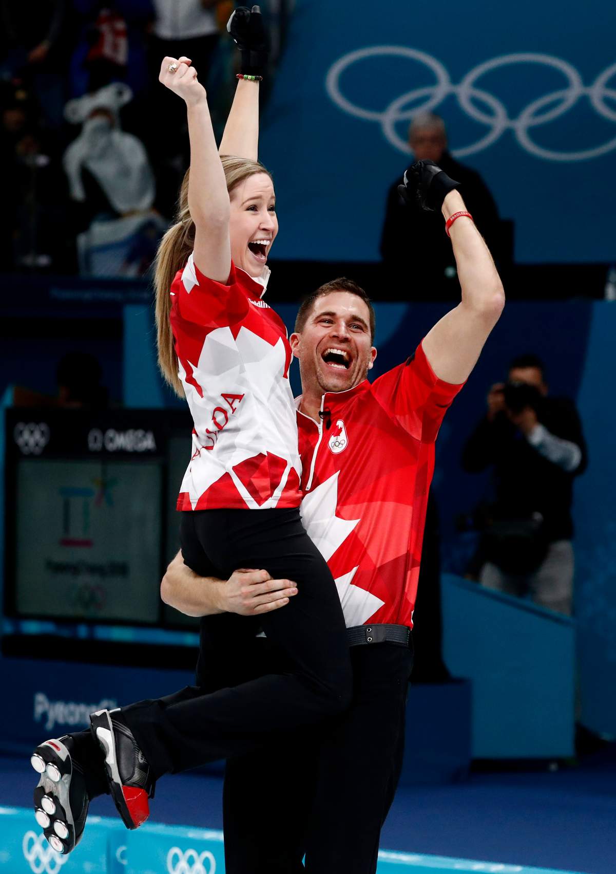 John Morris (R) celebrates with teammate Kaitlyn Lawes (L) of Canada after winning the gold medal against Switzerland during the Mixed Doubles Gold Medal Game at the Winter Olympic Games 2018.