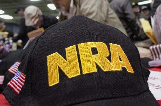 FILE- In this March 7, 2012 file photo, Illinois gun owners and supporters file out National Rifle Association applications while participating in an Illinois Gun Owners Lobby Day convention before marching to the Illinois state Capitol in Springfield, Ill. The troubled teen authorities say killed several people at a Florida high school on Wednesday, Feb. 14, 2018, excelled in an air-rifle marksmanship program supported by a grant from the National Rifle Association Foundation, part of a multimillion-dollar effort by the gun group to support youth shooting clubs. ().