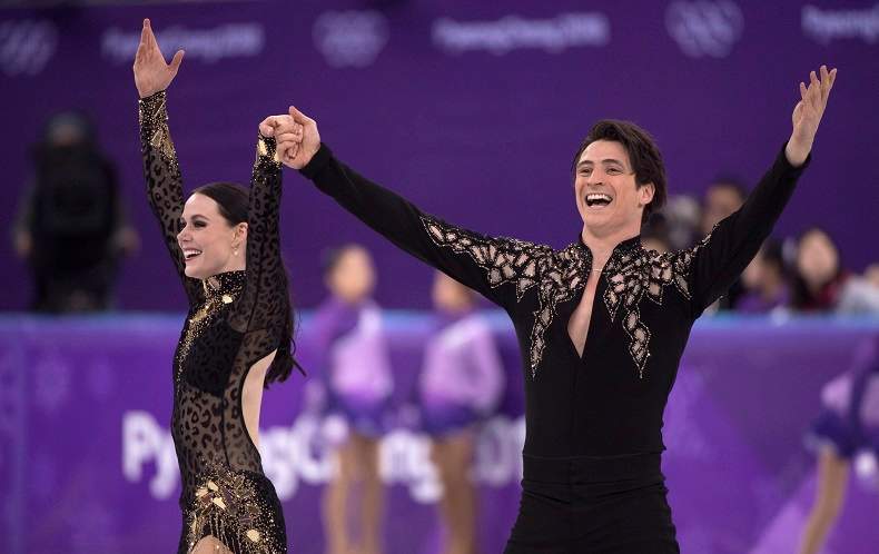 Canada’s Tessa Virtue and Scott Moir salute the crowd following their performance in the ice dance figure skating short program.