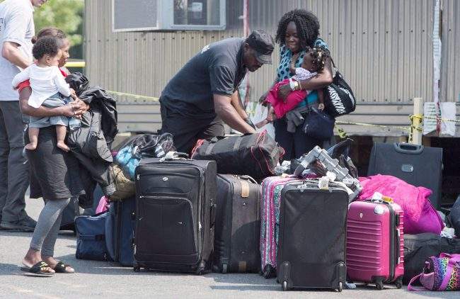 Asylum seekers sort out their luggage at a processing centre after crossing the border into Canada from the United States, August 21, 2017 near Saint-Bernard-de-Lacolle, Que.