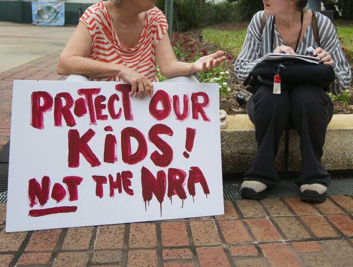 A woman holds a sign at the Florida state Capitol in Tallahassee, Florida.