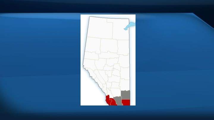 A map of Alberta. Areas marked in red were under a weather warning as of 8:30 p.m. on Monday night while areas marked in grey were under a blowing snow advisory.
