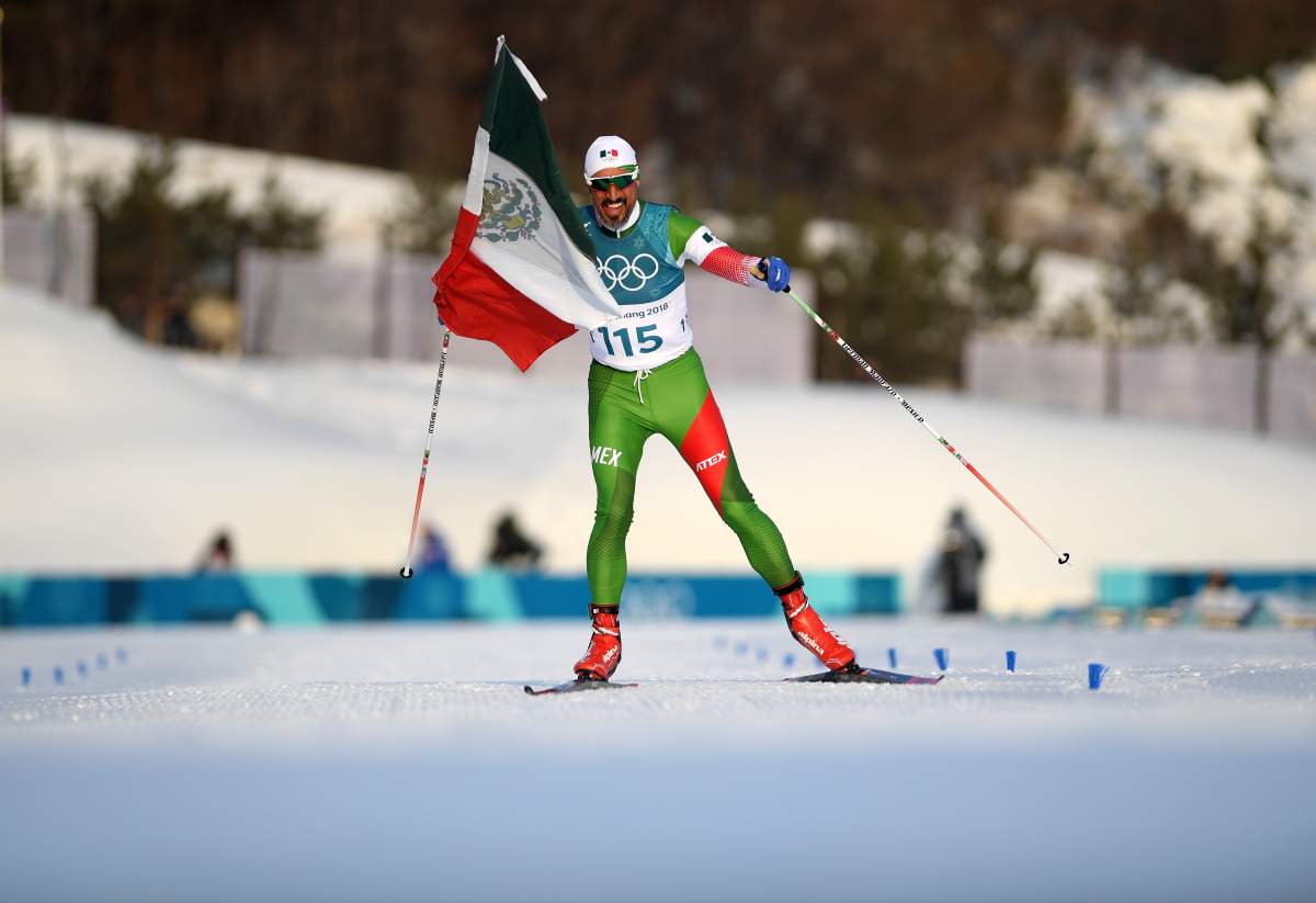German Madrazo of Mexico holds the flag of Mexico as he approaches the finish line during the cross-country skiing men’s 15 km race on Feb. 16, 2018 in Pyeongchang.