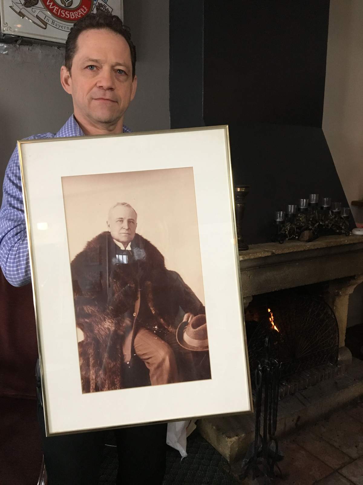 Mike Comeau with portrait of William T. Gibbard. Gibbard constructed the building in 1912.