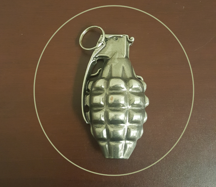 This is an image of a belt buckle in the shape of a hand grenade. 